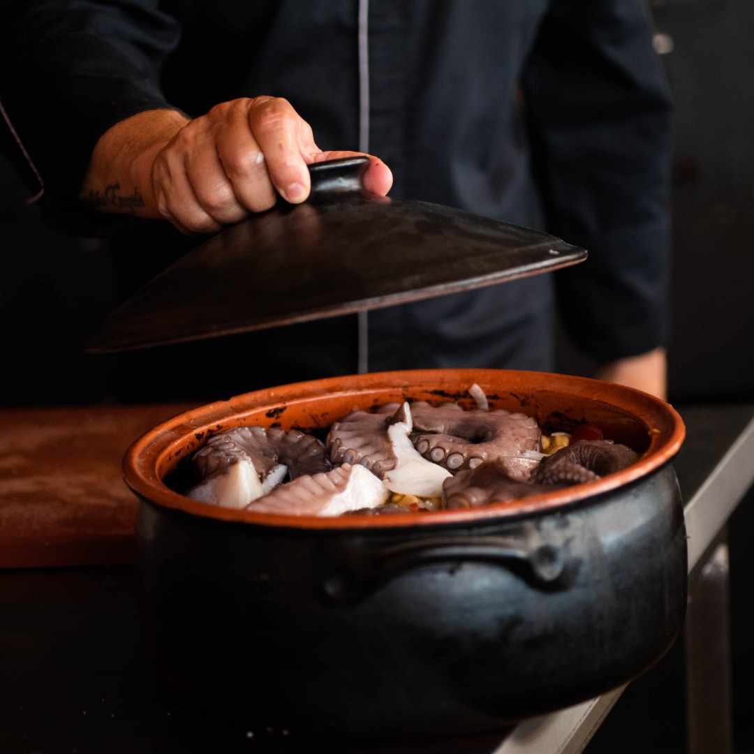 Octopus slow-roasting in the wood-fired oven, traditional Greek cooking at SeaRocks Paros