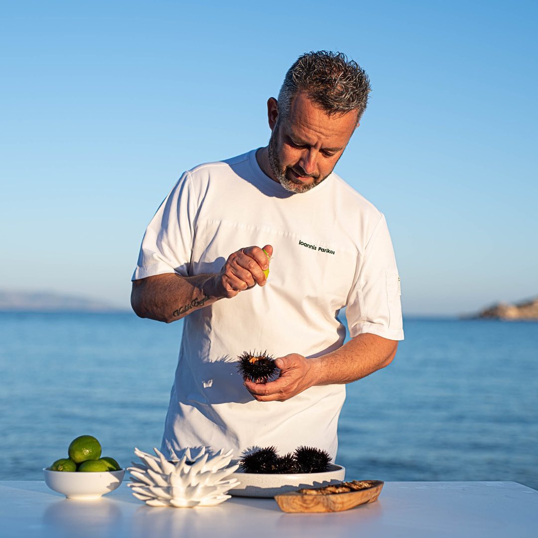 Chef Giannis Parikos preparing sea urchin seaside with the Aegean Sea behind, Ambelas Paros